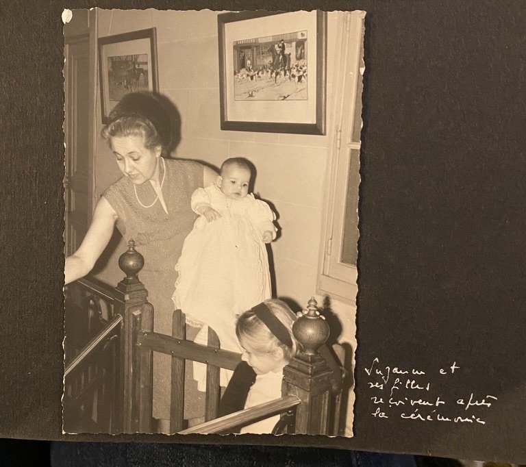 Suzanne tenant le bébé Armelle dans l'escalier après le baptême — adoption et filiation